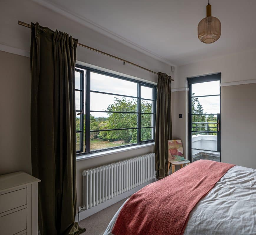 bedroom with salmon throw and aluco windows and doors 
