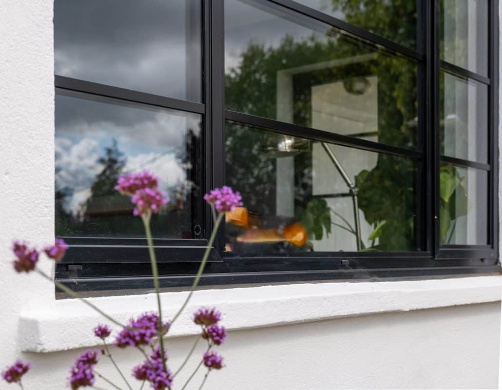 close up of steel look windows in bath showing art-deco window with flowers in front