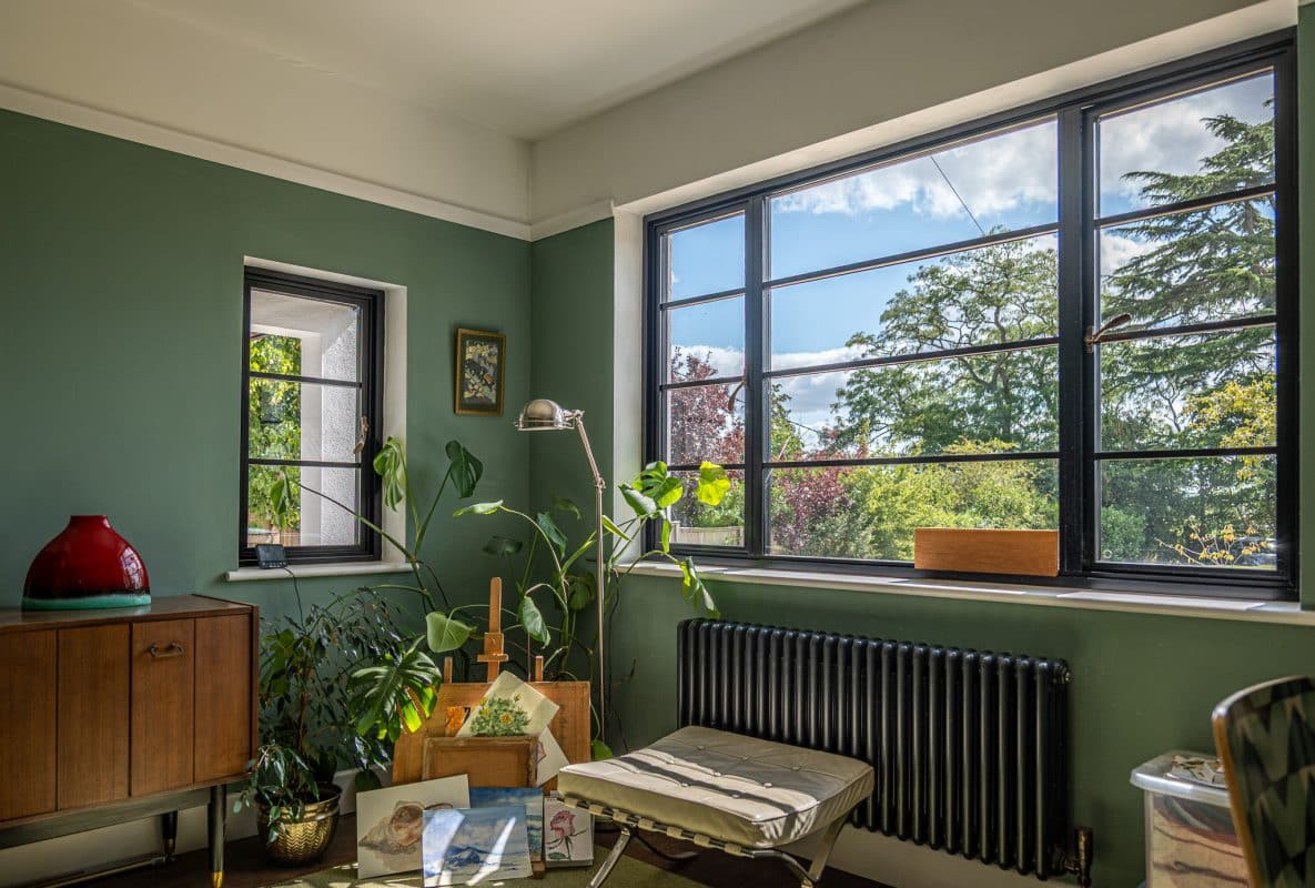 Picture of an Art-Deco inspired room with Aluco steel look windows on a sunny day. 