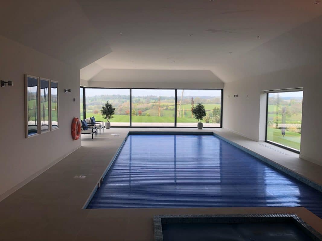 picture of a pool extension with the pool covered and sliding doors and picture windows in the background