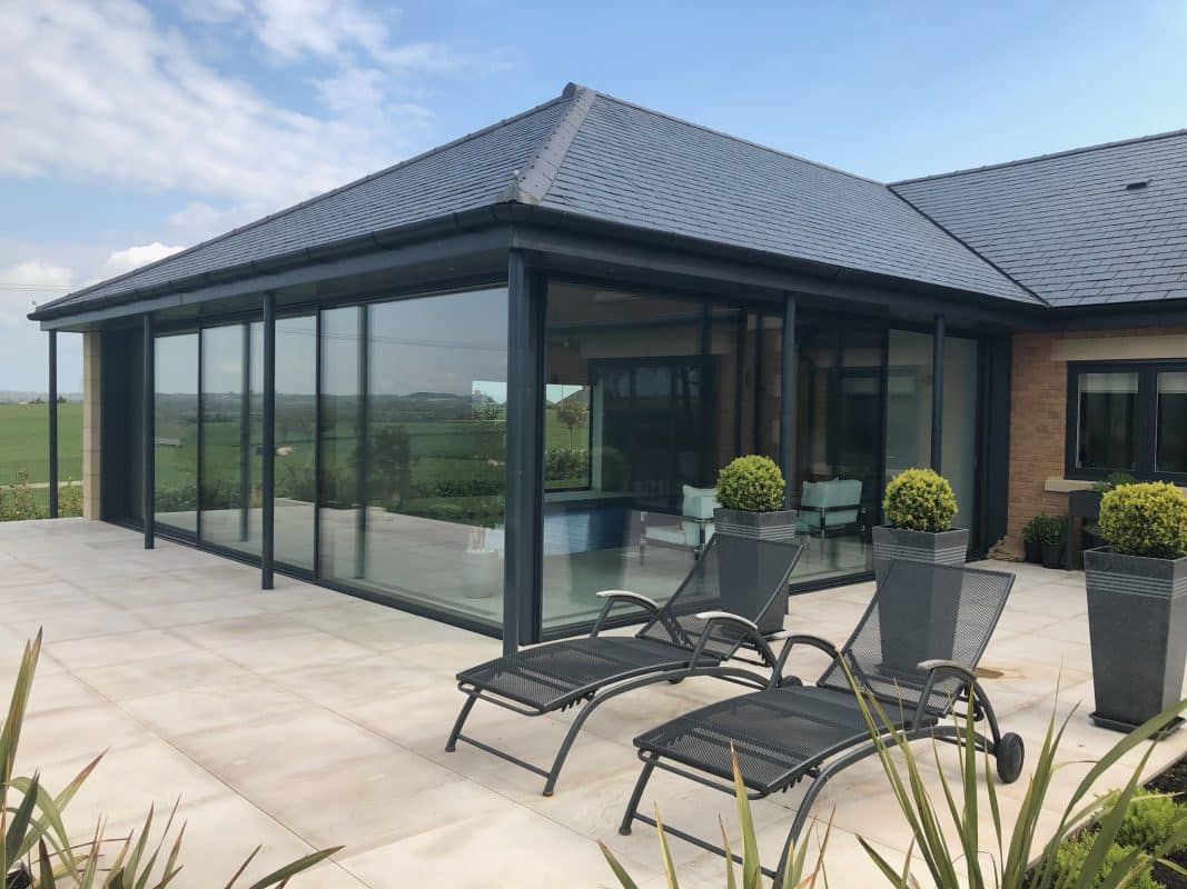 cero III grey sliding doors in a pool extension