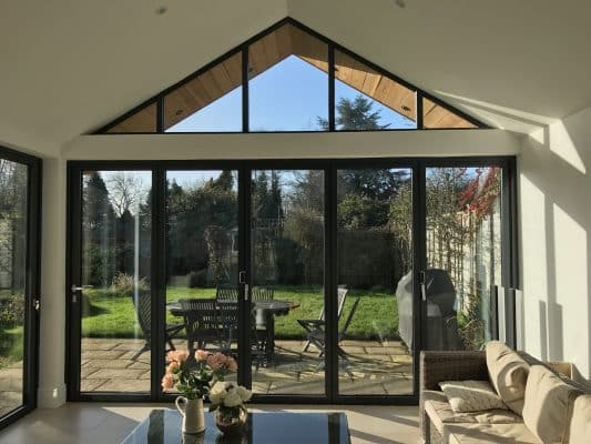 internal view of Schüco bifold doors with gable window above.
