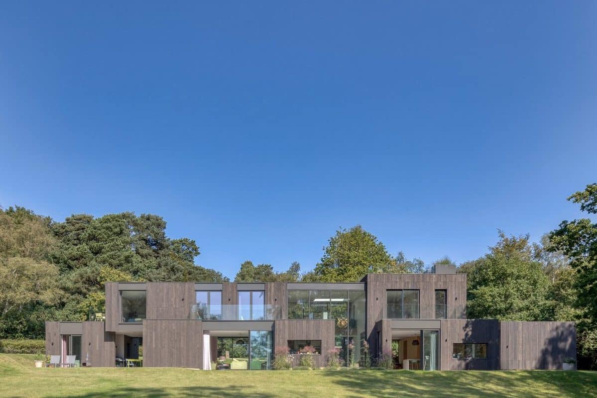 aluminium windows, curtain walling and solarlux sliding doors in a contemporary cedar clad home with blue sky.