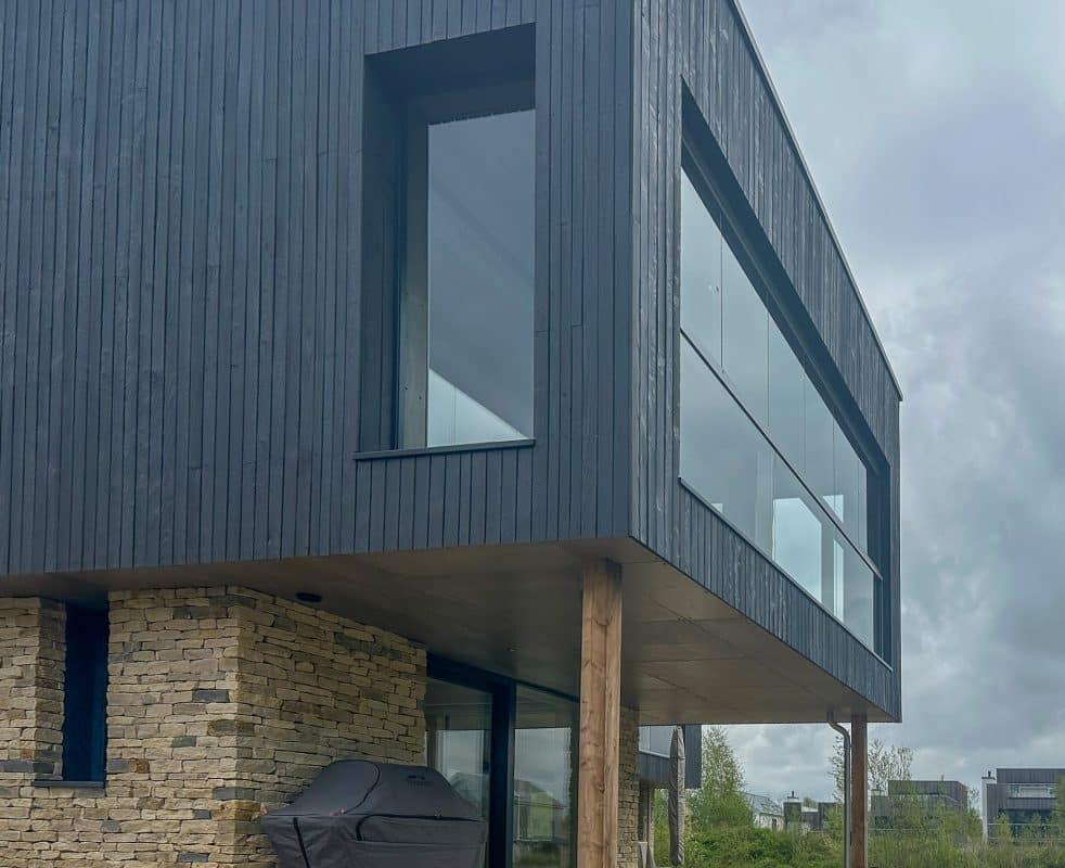 Grey Solarlux Balcony Enclosures to a timber-clad and brick contemporary home